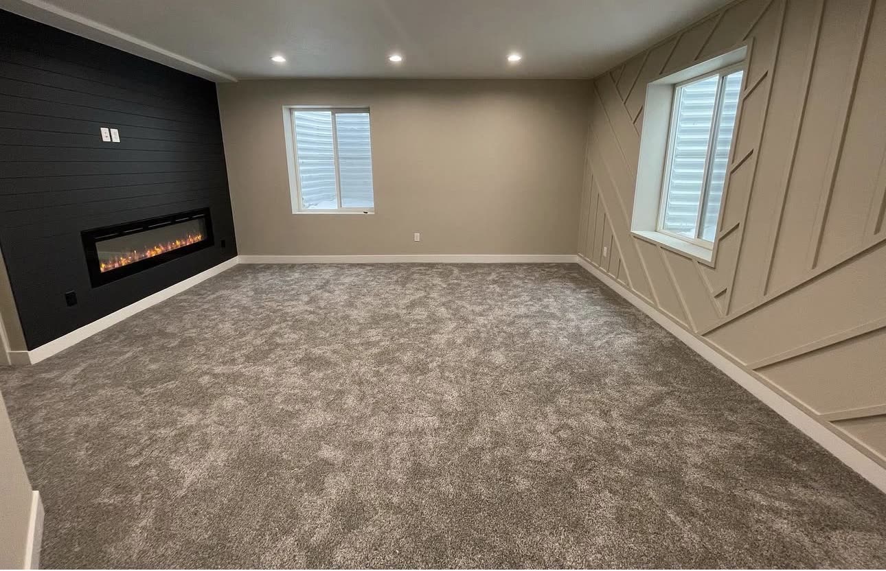 Finished basement with a shiplap fireplace wall